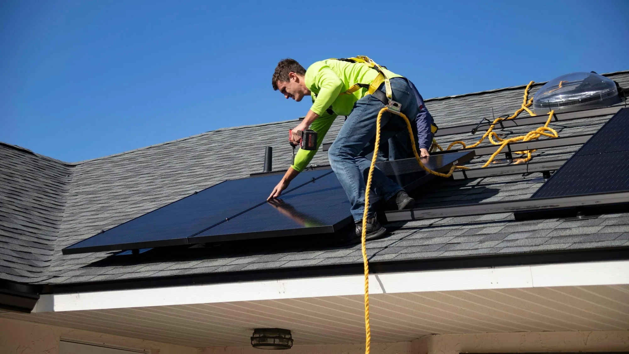 A clean tech installer fitting solar panels on a roof